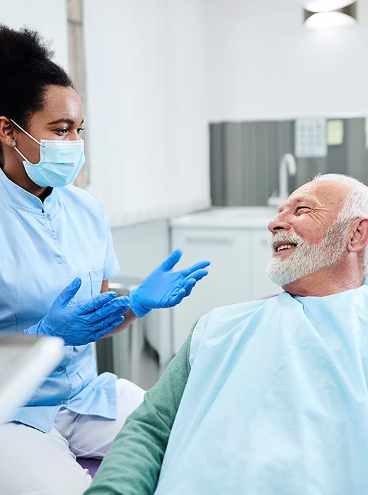 Smiling Invisalign patient holding an aligner