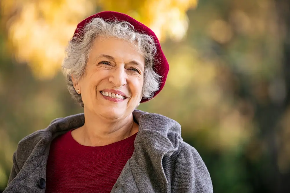 Patient smiling into a handheld mirror.
